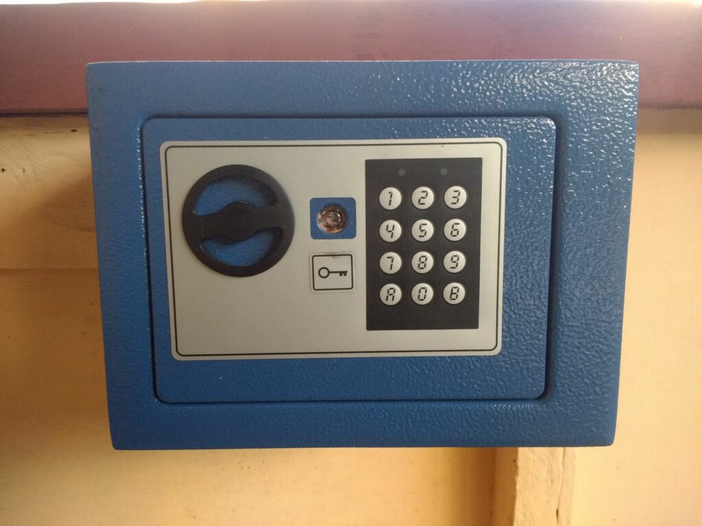 Photo of a blue safe with a numeric electronic keypad and a key cylinder