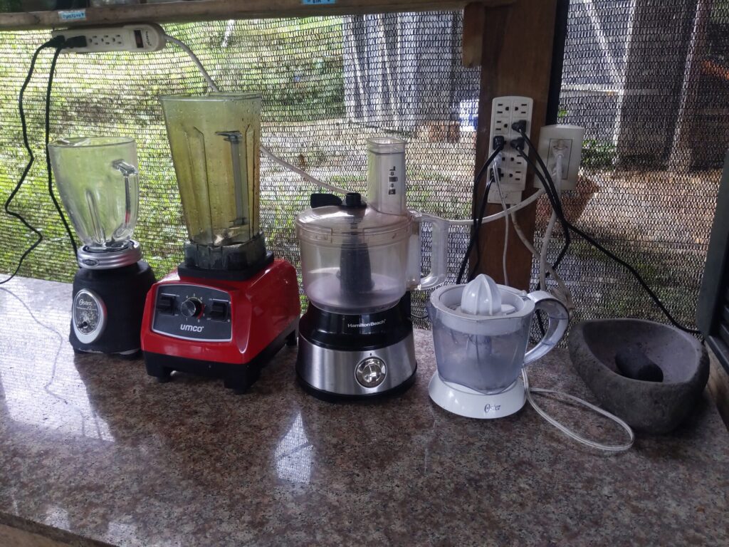 Photo shows two blenders, one food processor, and one citrus juicer