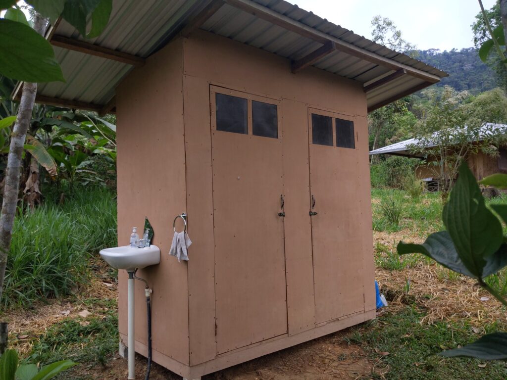 Photo of a small structure with two doors and a sink on its exterior wall