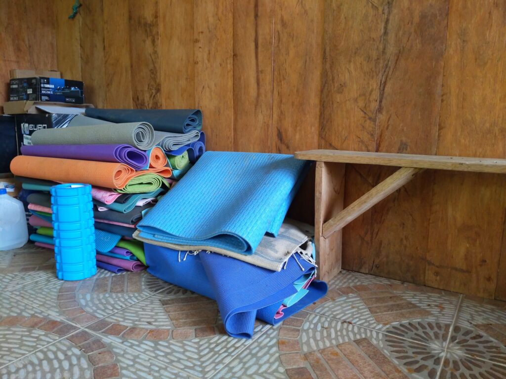 Photo of a pile of yoga mats next to a bench.
