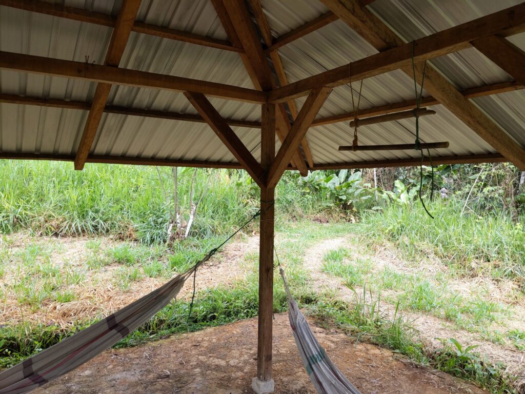 Photo shows two hammocks and a pull-up bar under a roof