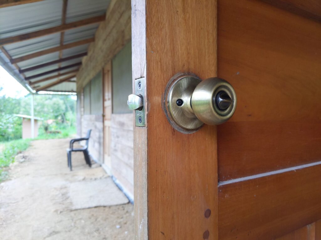 Photo of the inside of a door showing a knob lock and thumb turn